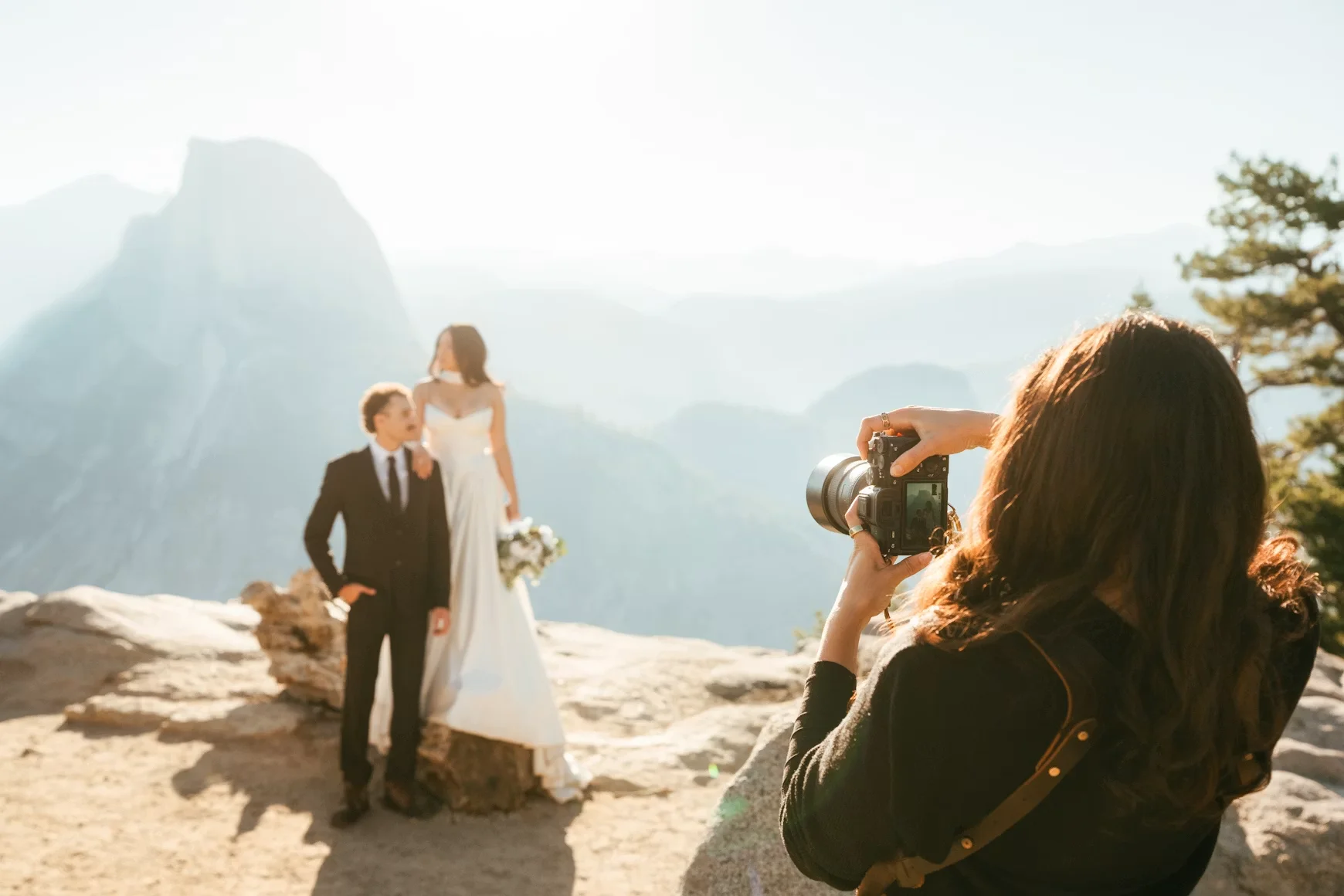 Bride and groom on a clifftop while their wedding photographer shoots them