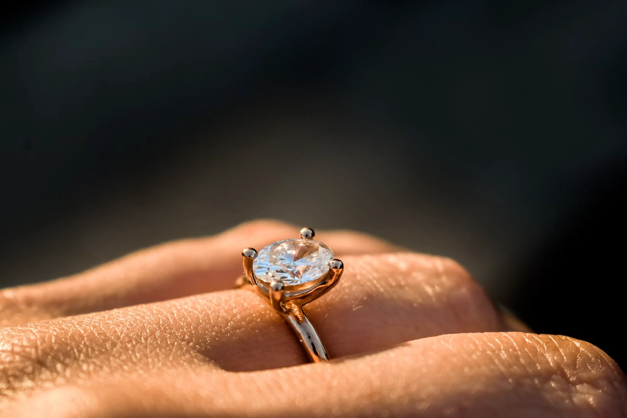 Close-up of an oval diamond solitaire engagement ring on a gold band