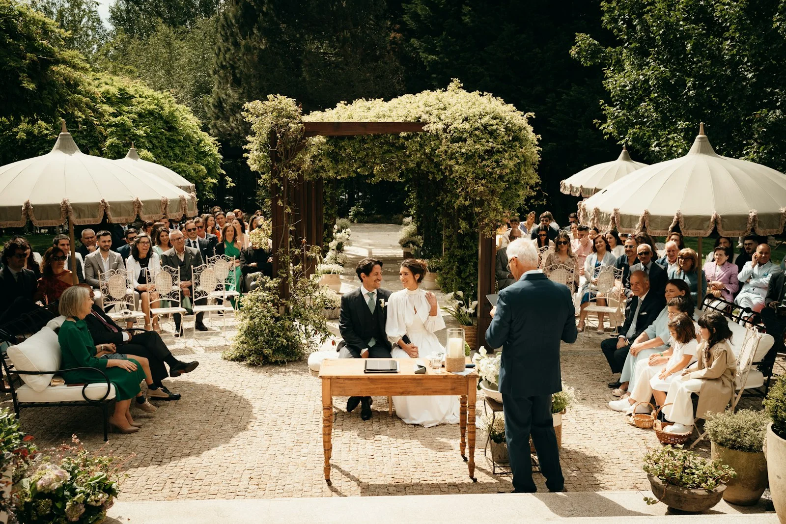 Officiant addressing a seated couple during an outdoor civil wedding ceremony