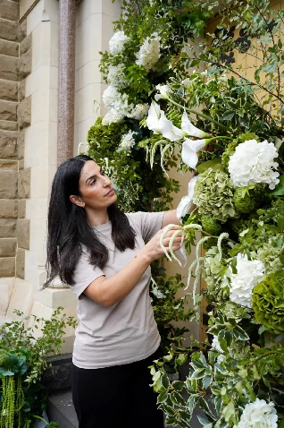 Florist from Once Upon a Flower styling a green and white floral wall