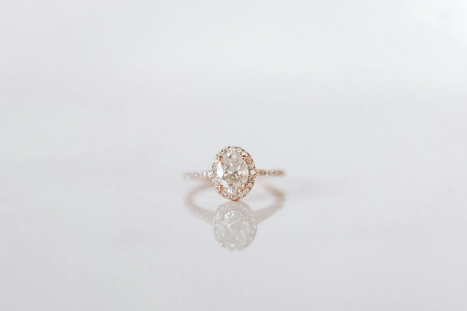 Blush-toned oval diamond halo ring in rose gold