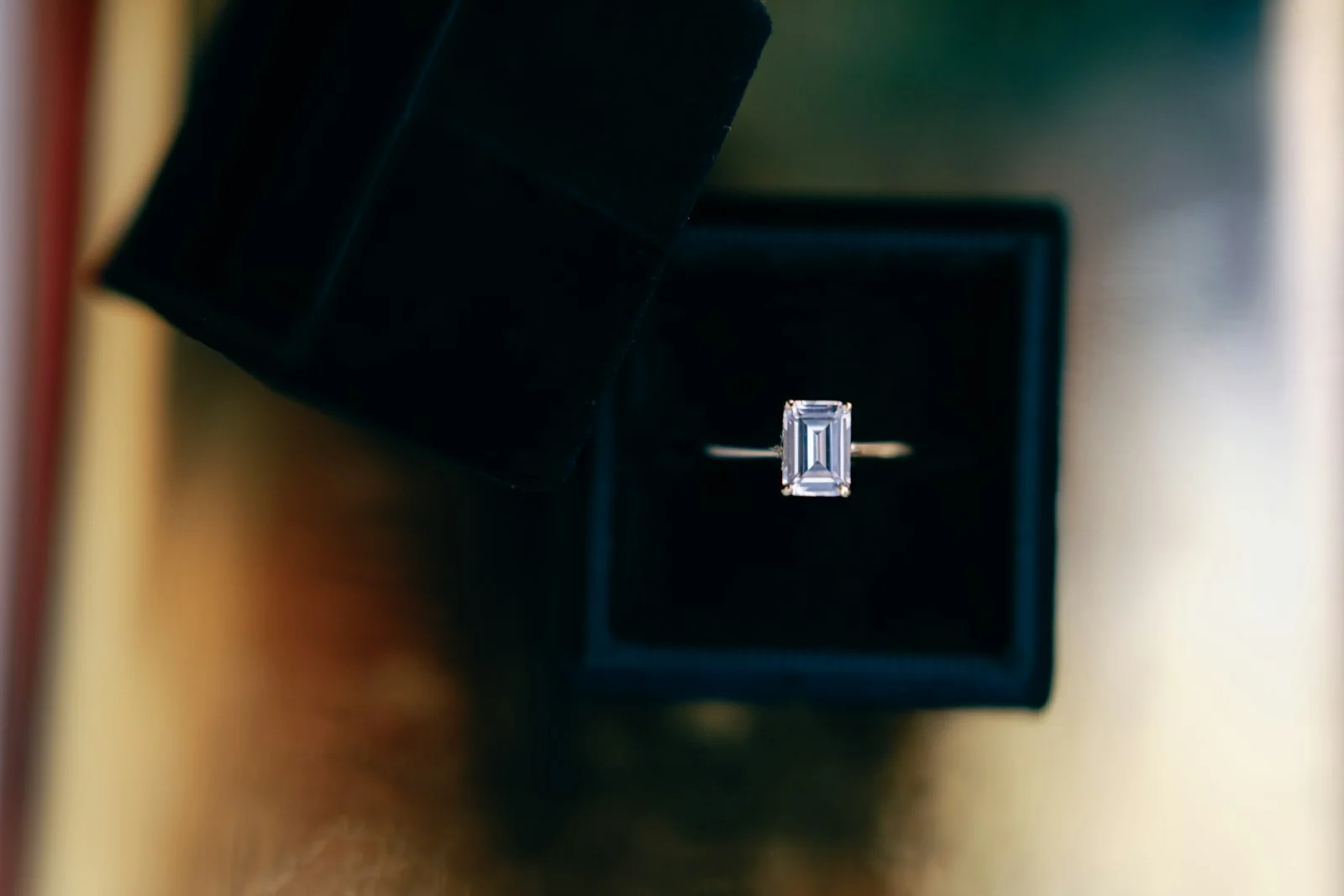 Emerald-cut solitaire on a fine band in a ring box