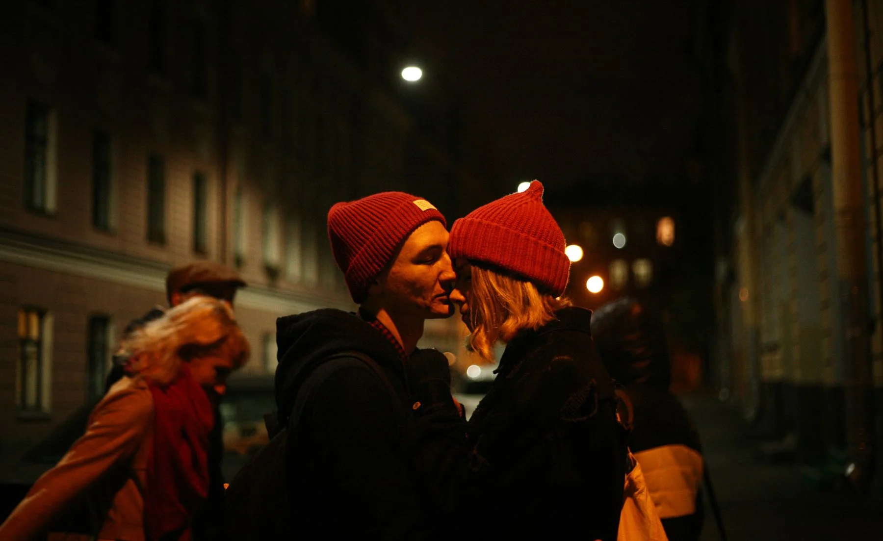 Couple sharing a kiss on a city street at night
