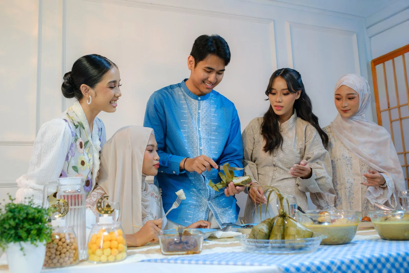 Guests around a festive dinner table of shared dishes and water jugs, for a UAE family’s alcohol-free brief | Wedded Wonderland