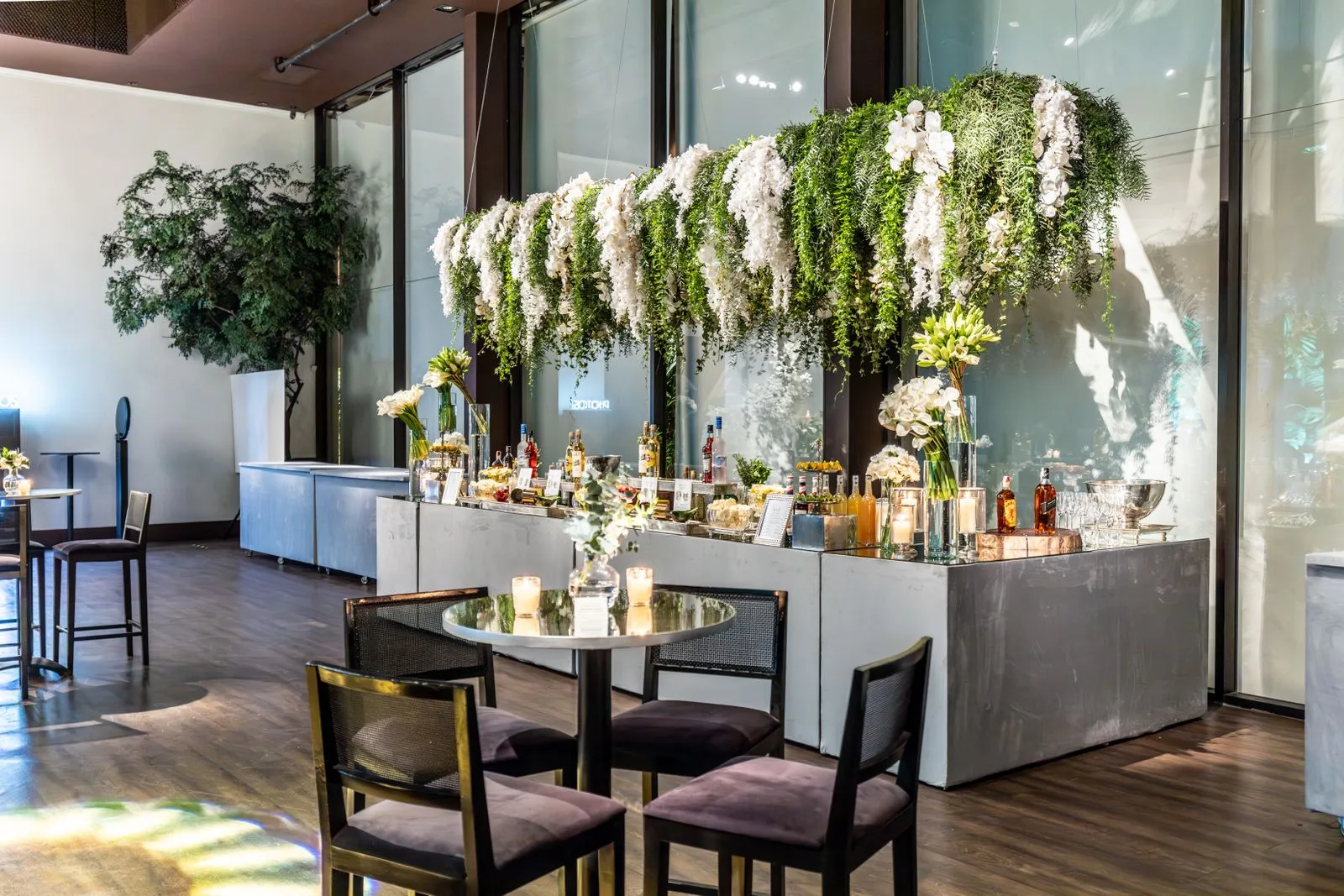 A wedding reception room with hanging florals and a bar, ready for guests | Wedded Wonderland