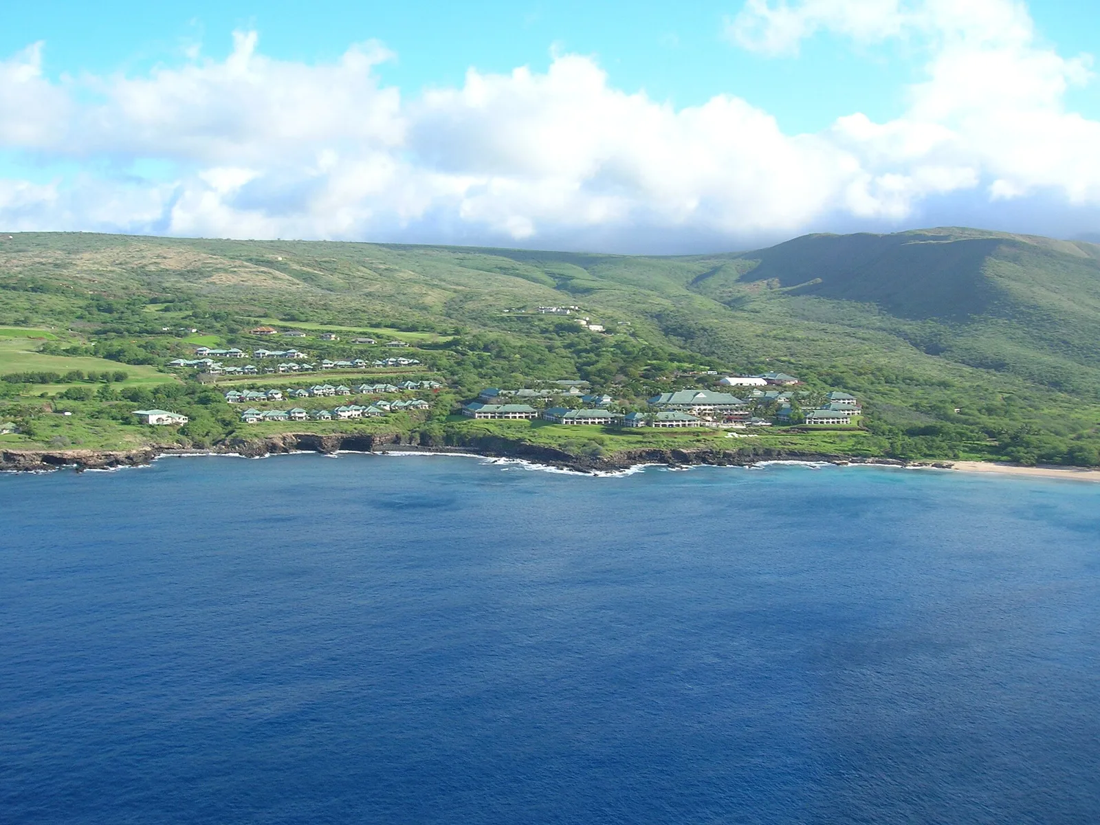 Manele Bay on Lanai with Four Seasons Resort Lanai on the hillside above the sea | Wedded Wonderland