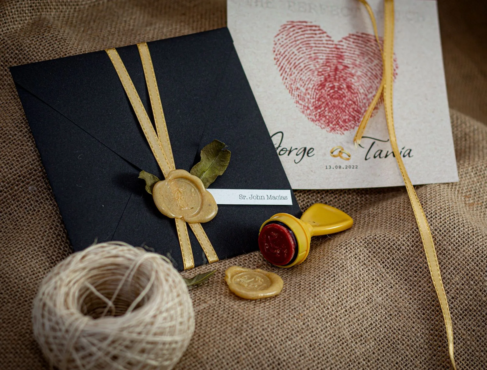 A black wedding invitation envelope with a gold wax seal and printed card | Wedded Wonderland