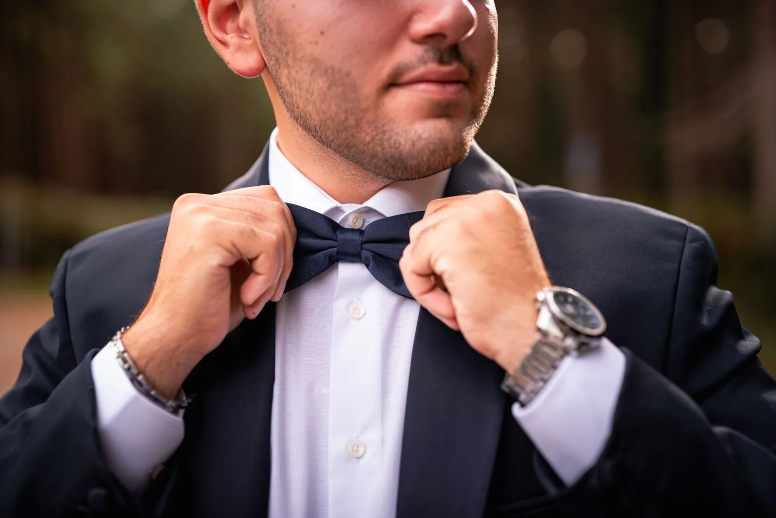Man adjusting the bow tie of a midnight dinner jacket, UK Savile Row black tie | Wedded Wonderland