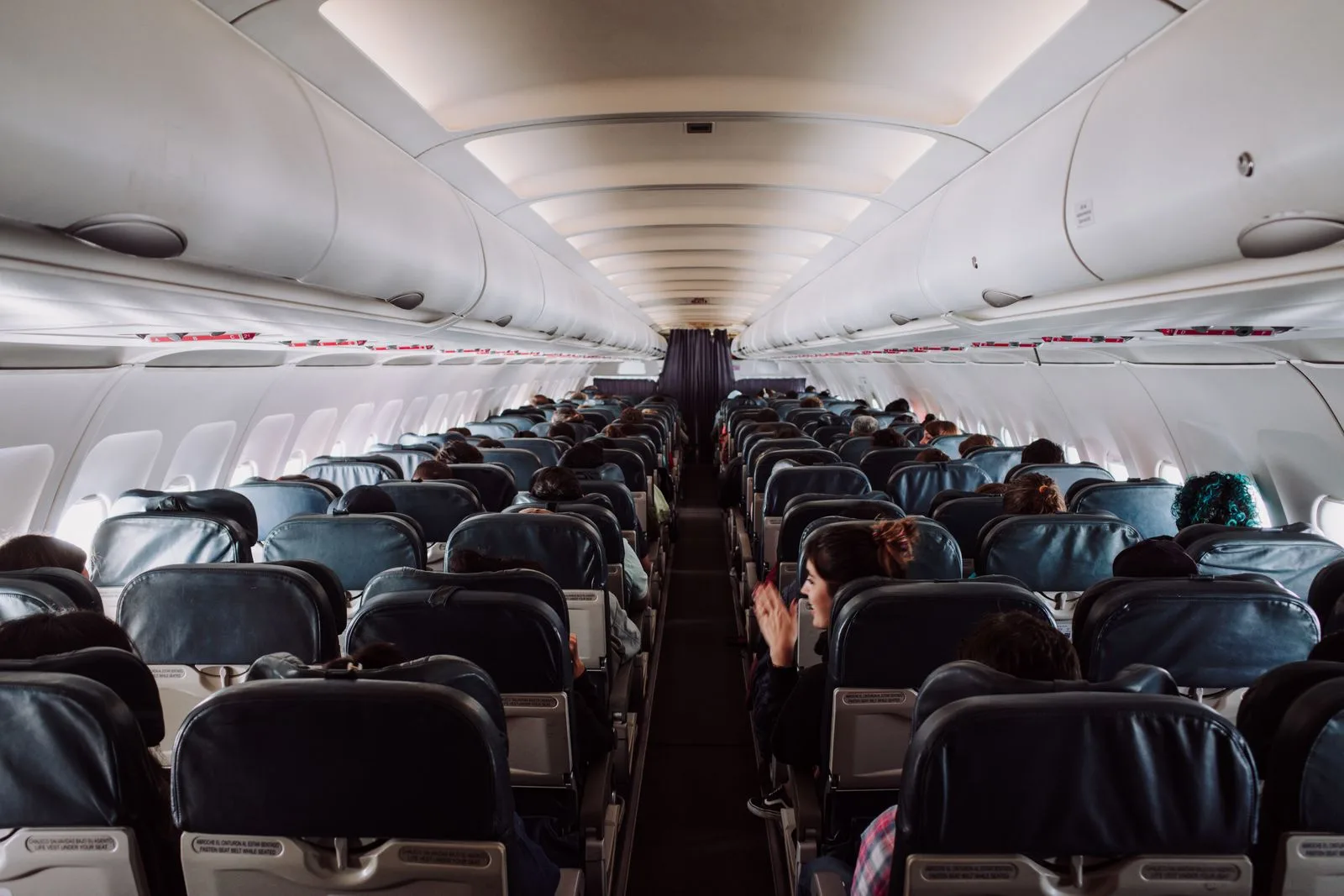 Passengers seated in an aircraft cabin on a long flight, the US route to Hawaii | Wedded Wonderland